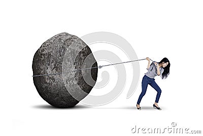 Female entrepreneur pulling big stone on studio Stock Photo