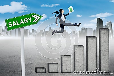 Female entrepreneur runs above salary graph Stock Photo