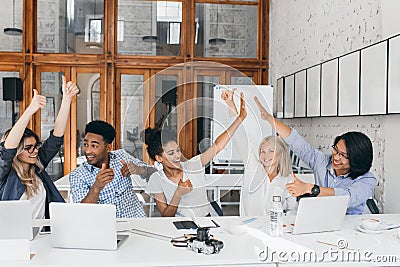 Female executive found the solution of problem and celebrating it with coworkers. Indoor portrait of glad asian Stock Photo