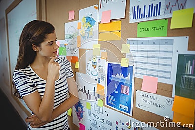 Female executive looking at bulletin board Stock Photo