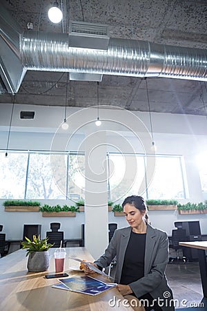 Female executive looking at documents at desk Stock Photo