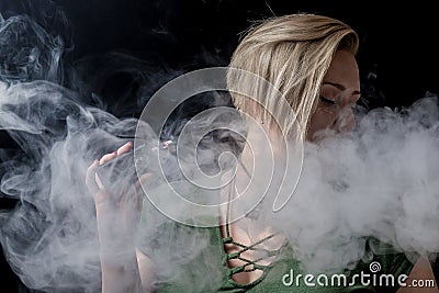 Female exhaling smoke and smoking vaporizer Stock Photo