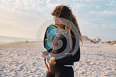 Female Extreme Sports Kite Surfer Prepping Kite On Beach At Sunset Stock Photo