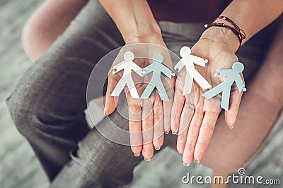 Female family therapist holding little models of couples in hands Stock Photo