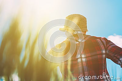 Female farmer looking at the sun on the horizon Stock Photo