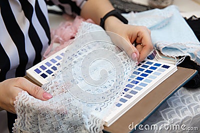 Female fashion designer holding color samples choosing fabric textile at workplace Editorial Stock Photo