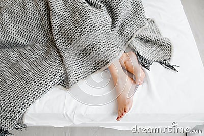 Female feet under blanket flat lay Stock Photo