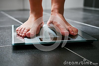 Female feet with weight scale in the bathroom Stock Photo