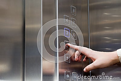 Female finger presses the button for the elevator Stock Photo