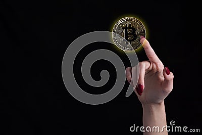 Female finger touching bitcoin over isolated black background Stock Photo