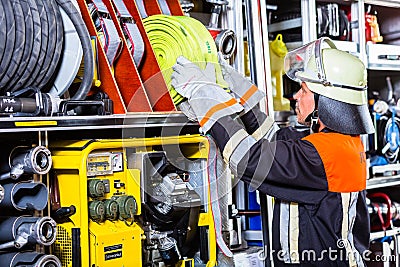 Fire fighters loading hoses into operations vehicle Stock Photo