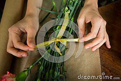 Female florist preparing bunch of flower in flower shop Stock Photo