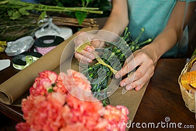 Female florist preparing bunch of flower in flower shop Stock Photo