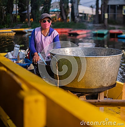 Female food vendor in yellow boat in Xochimilco lake Editorial Stock Photo