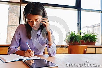 Female freelancer taking notes Stock Photo