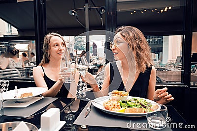 Female friends celebrating an event and toasting in restaurant Stock Photo