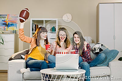 Female friends cheering sport league, watching football together at home. The Three emotional women on the sofa watch a Stock Photo