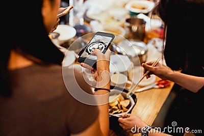 Female Friends dinner party In the house taking picture of new japanese noodles pot at home post on social media. Stock Photo