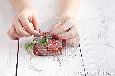 Female give present wrapped craft paper on aged wooden table, holiday gift box. Copyspace from corner Stock Photo