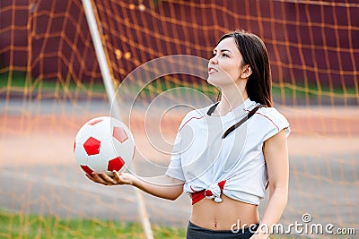 Female goalkeeper ball in his hands, standing at football goal Stock Photo