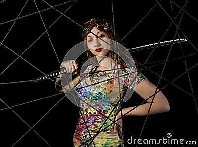 Female gothic warrior in pilot old glasses posing with katana sword Stock Photo