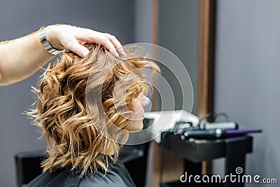 Female hairdresser checking woman`s hairstyle Stock Photo