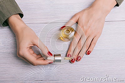 Female hand applied oil on the nails Stock Photo