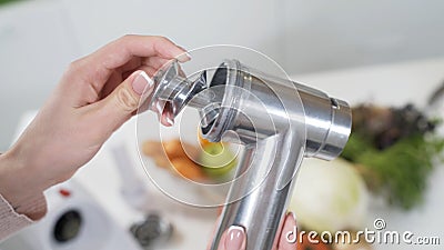 Female hand assembles meat grinder head for providing quality mince frommeat. Electric mincer machine for minced meat Stock Photo