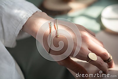 female hand with brass Copper bracelet and gold vintage stylish polished ring Stock Photo