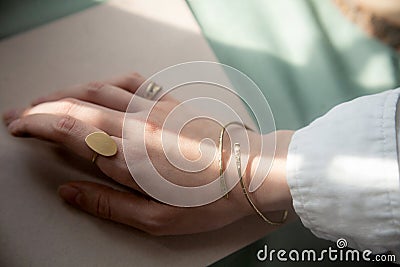 female hand with brass Copper bracelet and gold vintage stylish polished ring Stock Photo