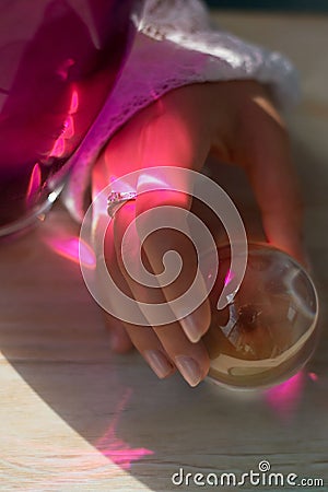 Female hand close to the countertop color glare. Mystique and mystique.Warm energy of light. Stock Photo