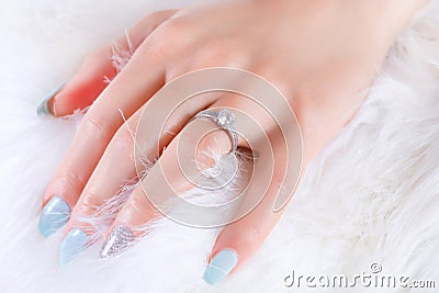 Radiant Beauty: Diamond Ring and Blue Manicure Stock Photo