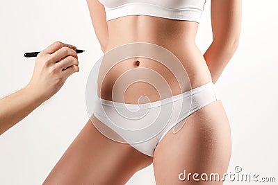 The female hand drawing lines on woman`s abdomen Stock Photo