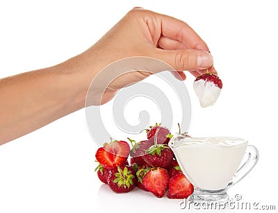Female hand dunked strawberry into cup with cream Stock Photo