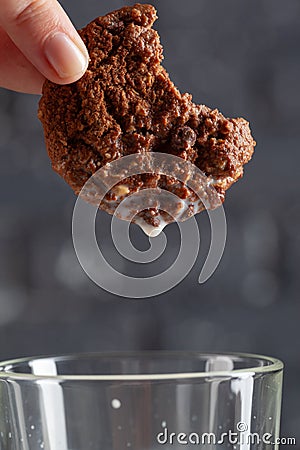 Female hand dunking cookie in milk close up Stock Photo