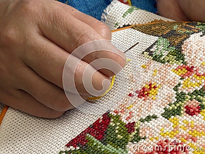 Female hand embroider at cross Stock Photo