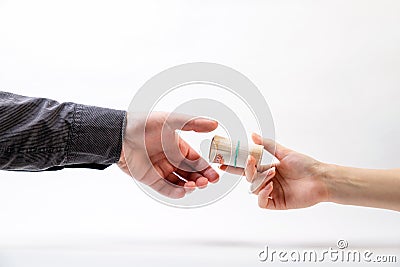 A female hand gives a bribe, roll of money, the male hand in a shirt. Side view. White background. The concept of the world anti- Stock Photo