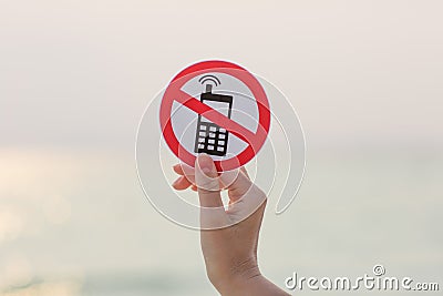 Female hand holding No phone calls sign on the beach Stock Photo