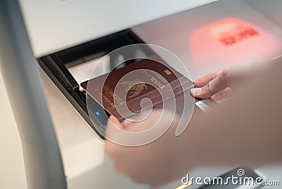 Female hand holding personal passport scaning at the self service checkin counter for get boarding pass at the airport terminal Stock Photo