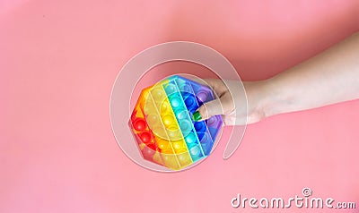 Female hand holding rainbow color antistress toy pop it Stock Photo