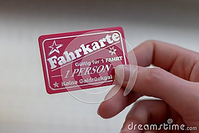 female hand holding a ticket for a carnival ride with german text: ticket, valid for 1 ride, 1 person, no cashback , plaerrer, Editorial Stock Photo