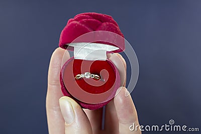 Female hand holds a ring offer engagement Stock Photo