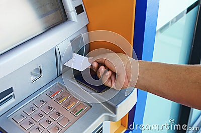 Female hand inserting ATM card into ATM bank machine Stock Photo