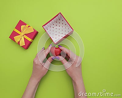 female hand manicure, surprise gift box heart on colored background Stock Photo