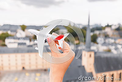 hand with a model aircraft on the background of the sights of Luxembourg. Concept of airline and air transport Stock Photo