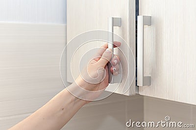 Female hand open the cupboard doors, close up. Stock Photo