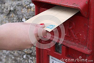 A female hand posting a letter in a post box in the UK Editorial Stock Photo