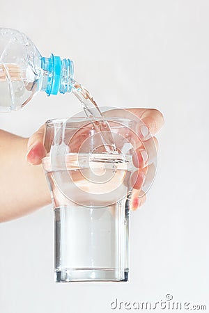 Female hand pour mineral water into a glass from bottle Stock Photo