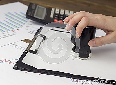 A female hand puts a seal on a blank sheet contract Stock Photo