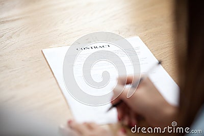 Female hand putting signature on business contract, focus on doc Stock Photo